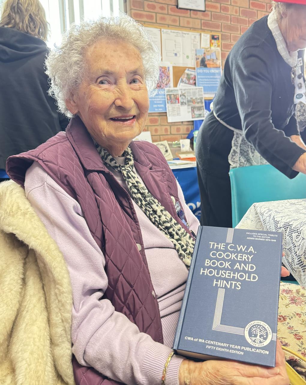 CWA member Norma Mckenzie, pictured with a CWA cookbook.  