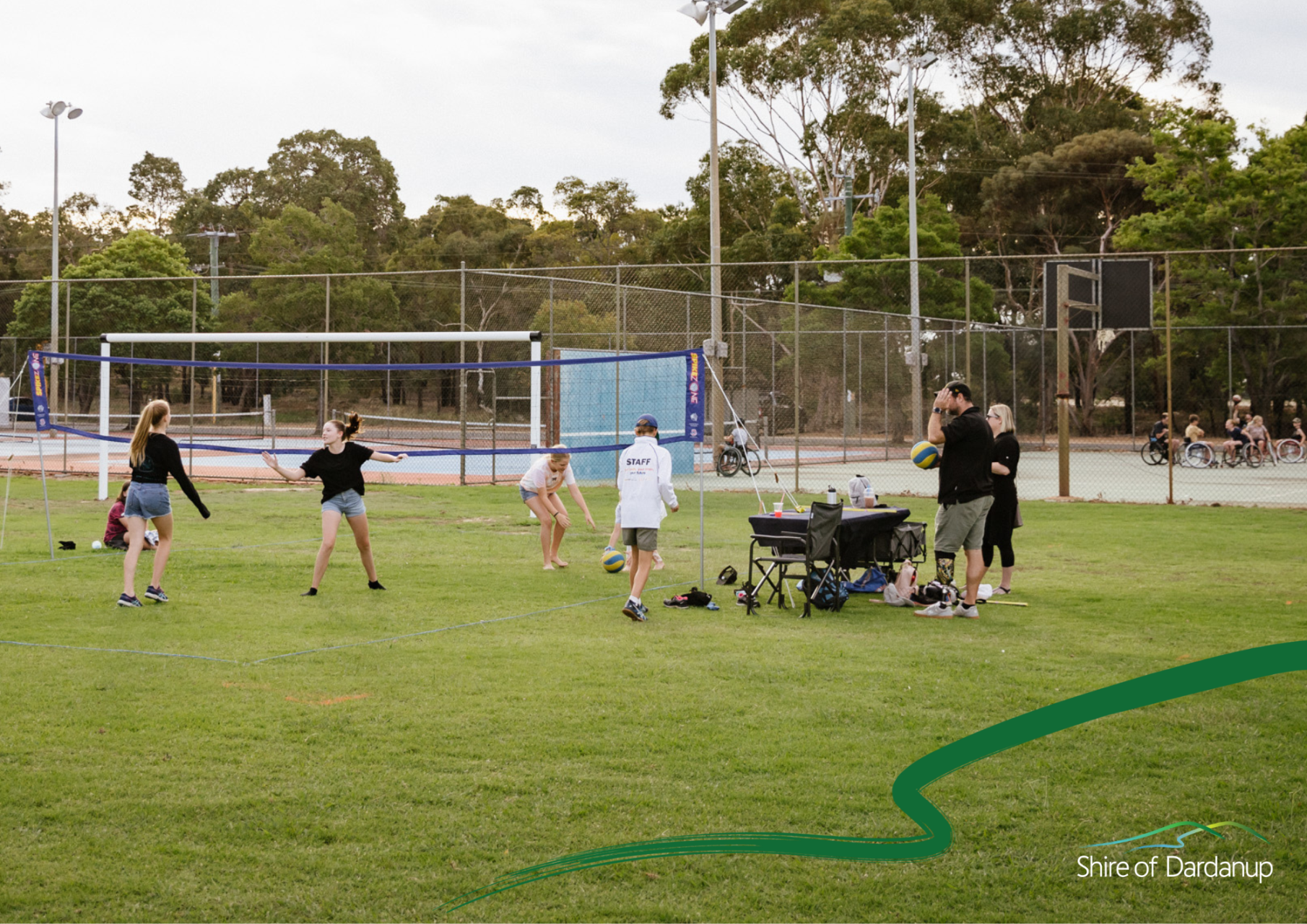 Group of people playing volleyball on a field