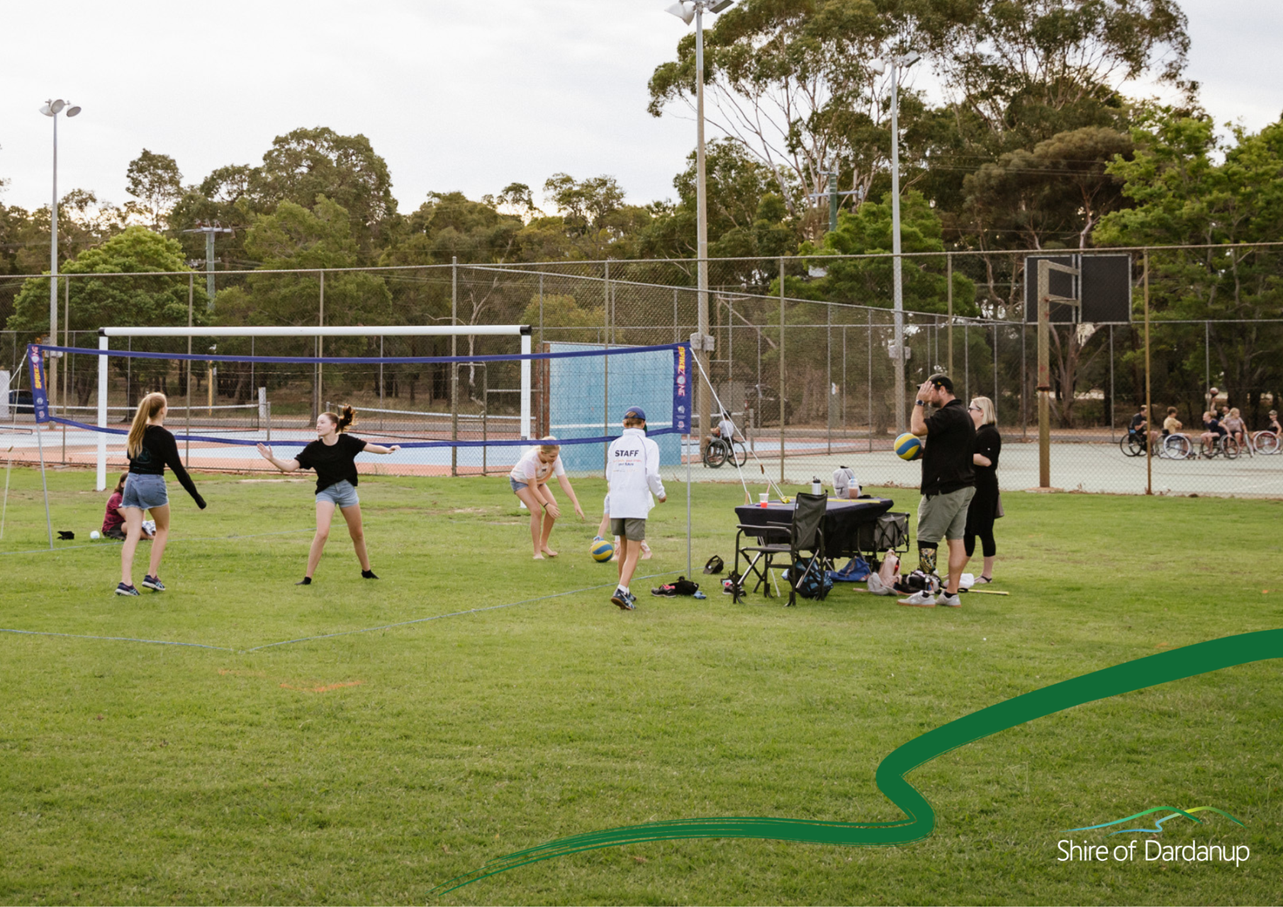 Group of people playing volleyball on a field 